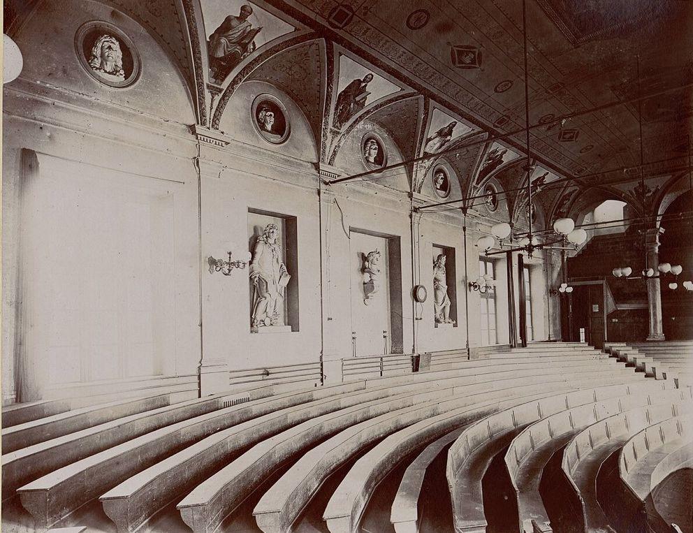 Photographie de 1892 : les gradins vides du grand amphithéâtre de l'ancienne Sorbonne, face à l'estrade.